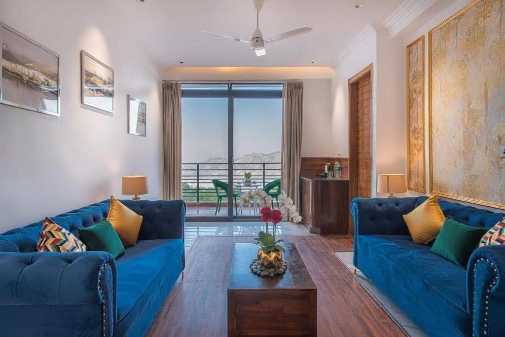 a living room with two blue couches and a table at Silver wings Kasauli in Kasauli