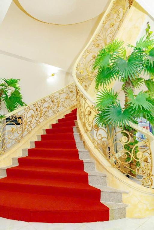 a red carpeted staircase with a red carpet and a stair case at Ruby Hotel Front Of Beach 2 in Bình Sum