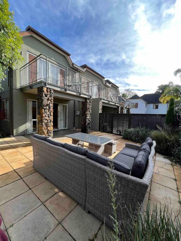 a large couch on a patio in front of a house at Villa 46 in Pauanui