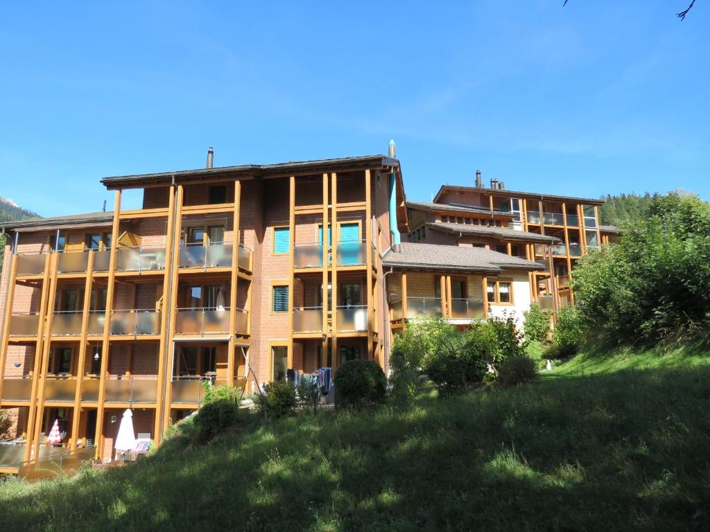 ein großes Apartmenthaus auf einem Hügel mit Hof in der Unterkunft Sunshine 2 in Fiesch