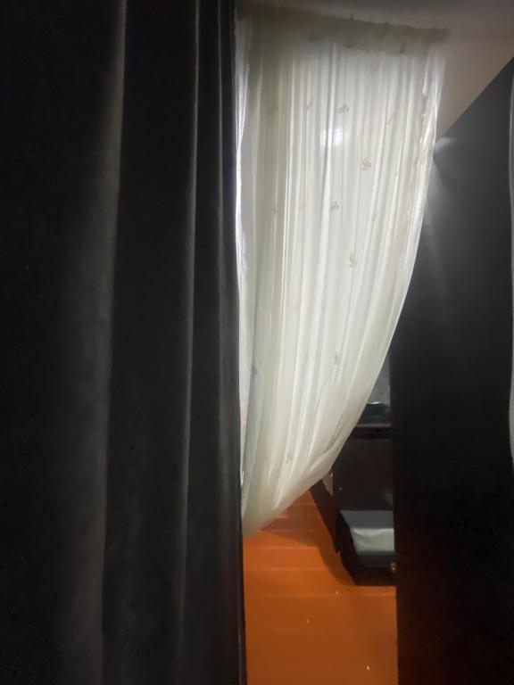 a window with a curtain in a room at ใจกลม โฮมคาเฟ่ in Ban Hua Phrong