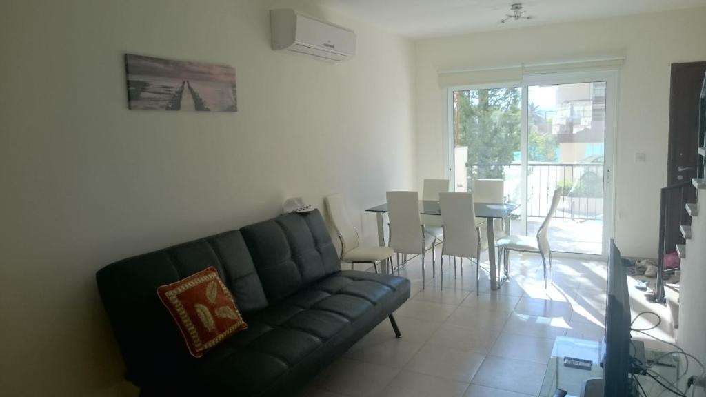 uma sala de estar com um sofá e uma mesa com cadeiras em Townhouse Luck in Polis em Pólis