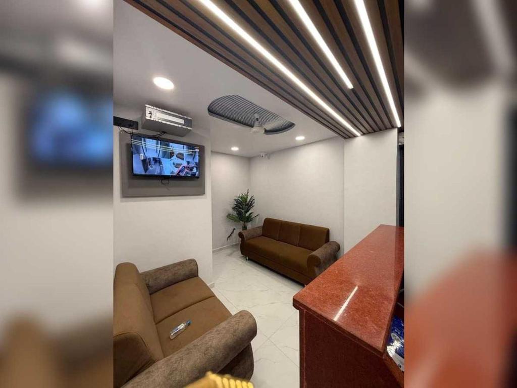 een woonkamer met een bank en een flatscreen-tv bij SPOT ON SBL HOTEL ROOMS in Surat
