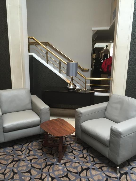 a lobby with two chairs and a table and stairs at Park Inn by Radisson Shannon Airport in Shannon