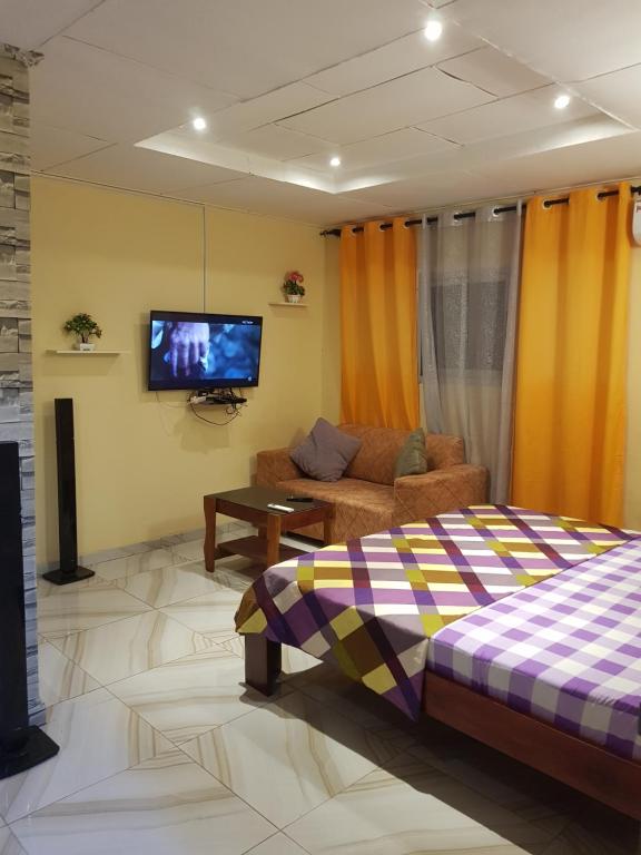 un soggiorno con un divano e una TV di Résidence Yamoussoukro a Yamoussoukro
