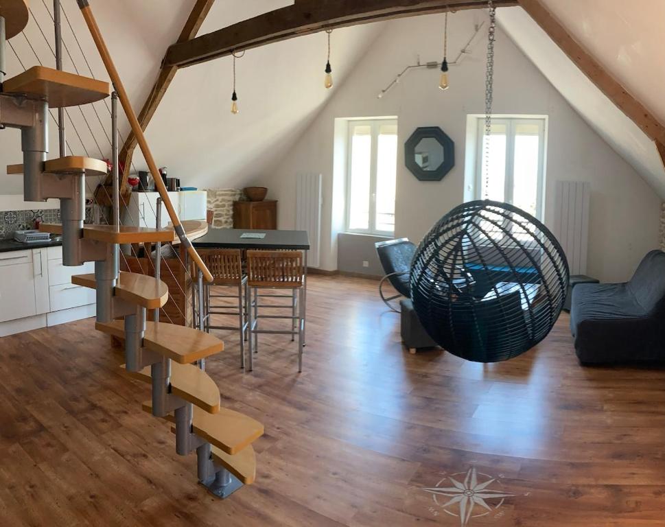a living room with a spiral staircase in a loft at Appartement centre in Quiberon