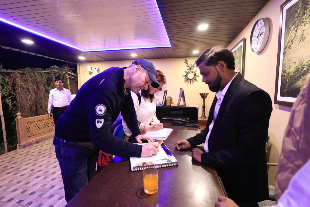 a man is standing at a table signing a paper at Jungle View Resort Ranthambhore in Khilchipur