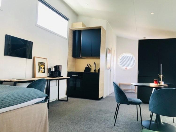 a room with a bed and a table and a kitchen at Private apartment with hotel feeling in Hudiksvall