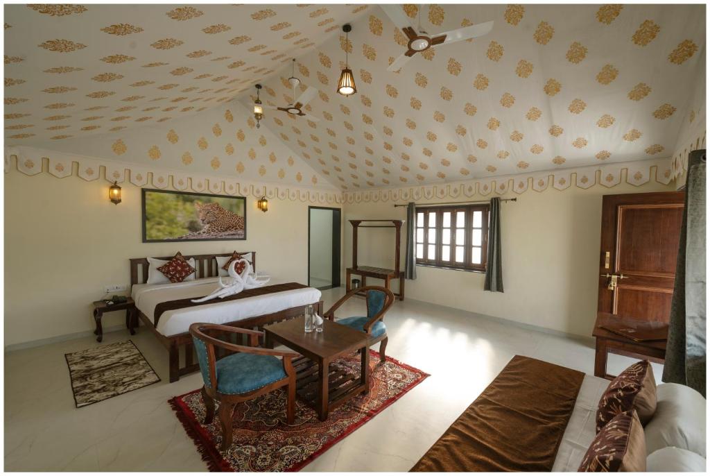 een slaapkamer met een bed, een tafel en stoelen bij Upvan Jawai - Unit of Dev Group in Bāli