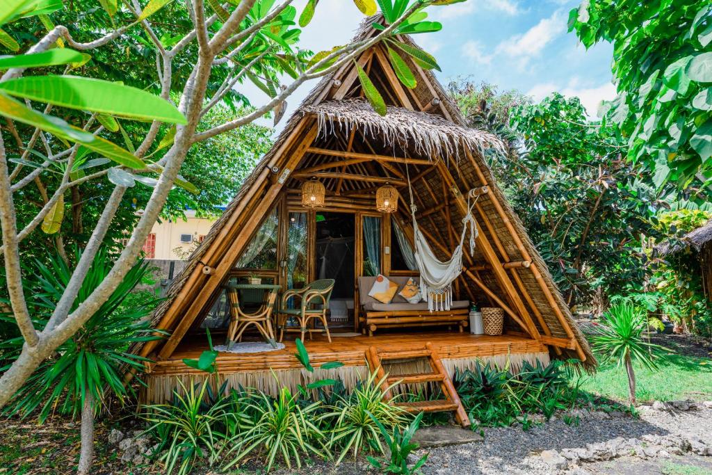 a thatch roofed hut in the middle of a forest at Tongo Hill Cottages in Moalboal