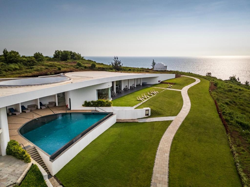 an external view of a house with a swimming pool at Araqila in Vengurla