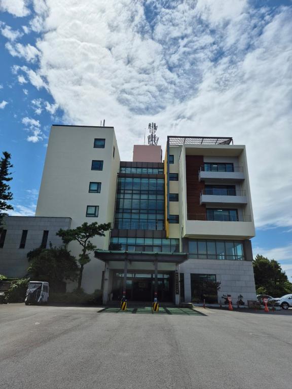 a building with a parking lot in front of it at Hallasan Resort in Sanch'ŏndan