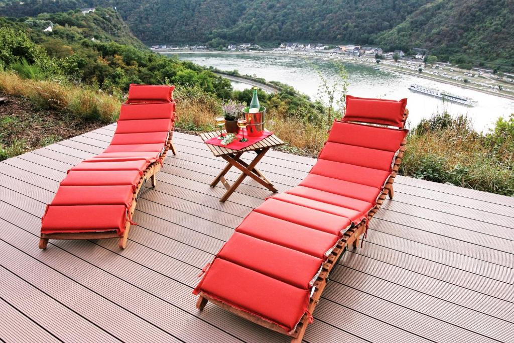 a group of chairs and a table on a wooden deck at Loreley Hills in Sankt Goarshausen