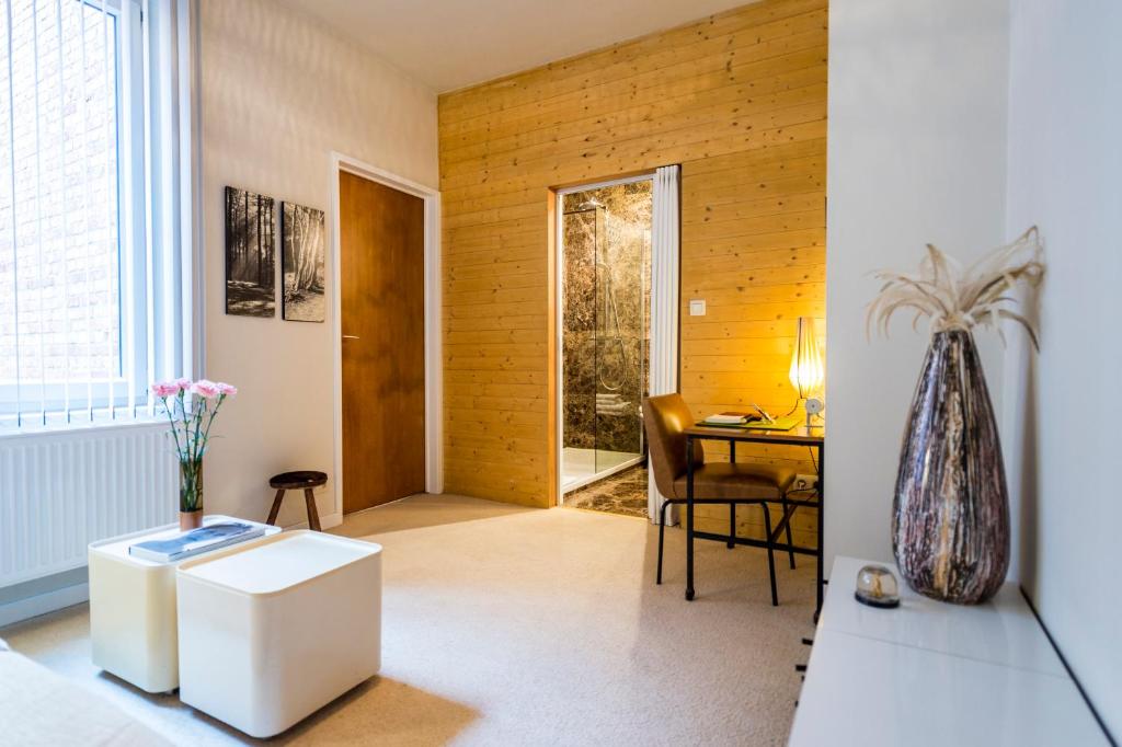un soggiorno con tavolo e vaso di Aplace Antwerp - marvellous flats & hotel rooms ad Anversa