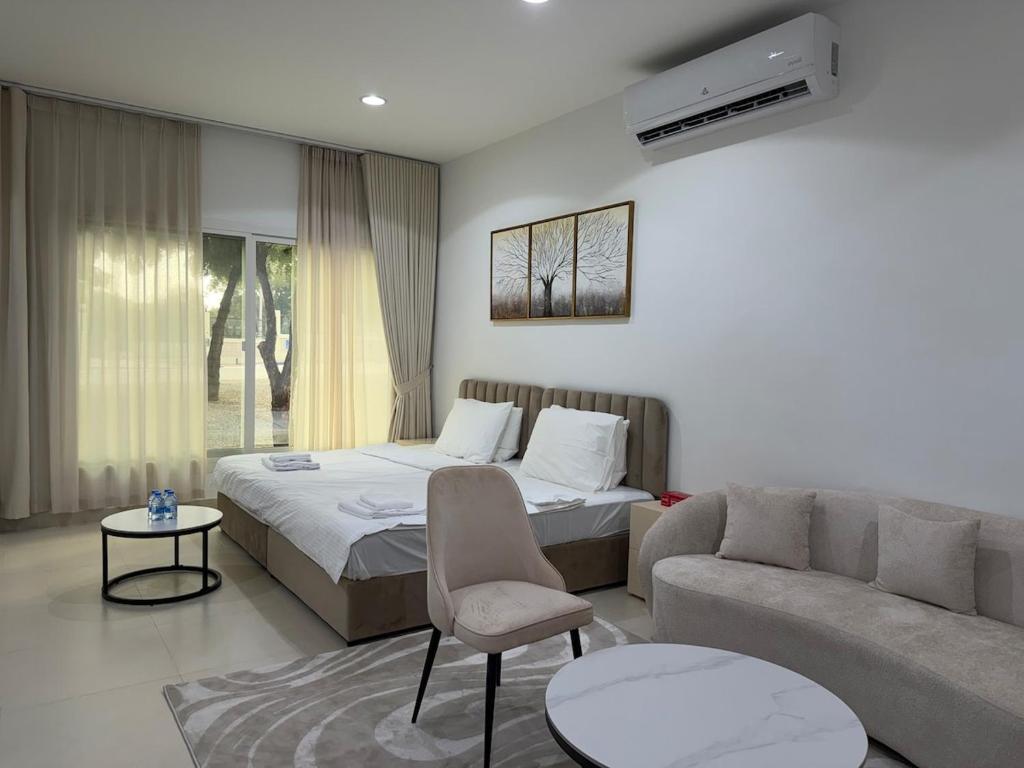 een hotelkamer met een bed en een bank bij Sky5 Apartment in Hatta