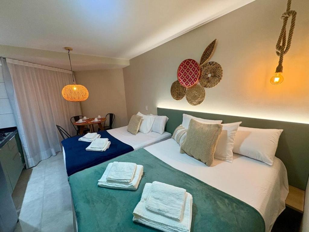 a bedroom with two beds with towels on them at Studio Praia de Carneiros in Praia dos Carneiros