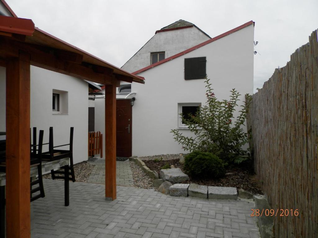ein weißes Haus mit einem Zaun und einer Terrasse in der Unterkunft Apartmán u Jacka in Rumburk