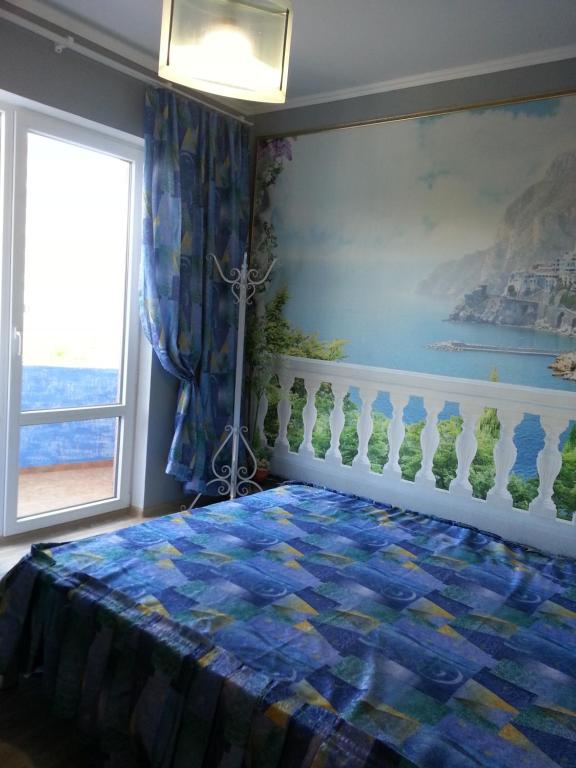ゲレンジークにあるПервая береговаяのベッドルーム1室(壁に絵画が描かれたベッド1台付)