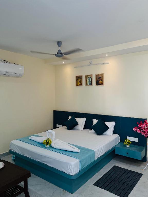 a bedroom with a bed with blue and white sheets at GOKUL Hotel in Maheshwar