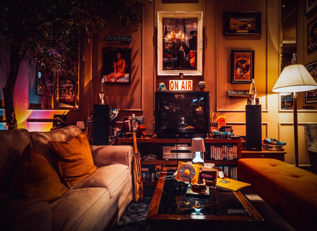 A richly decorated lounge with a sofa, television, records, and framed art.
