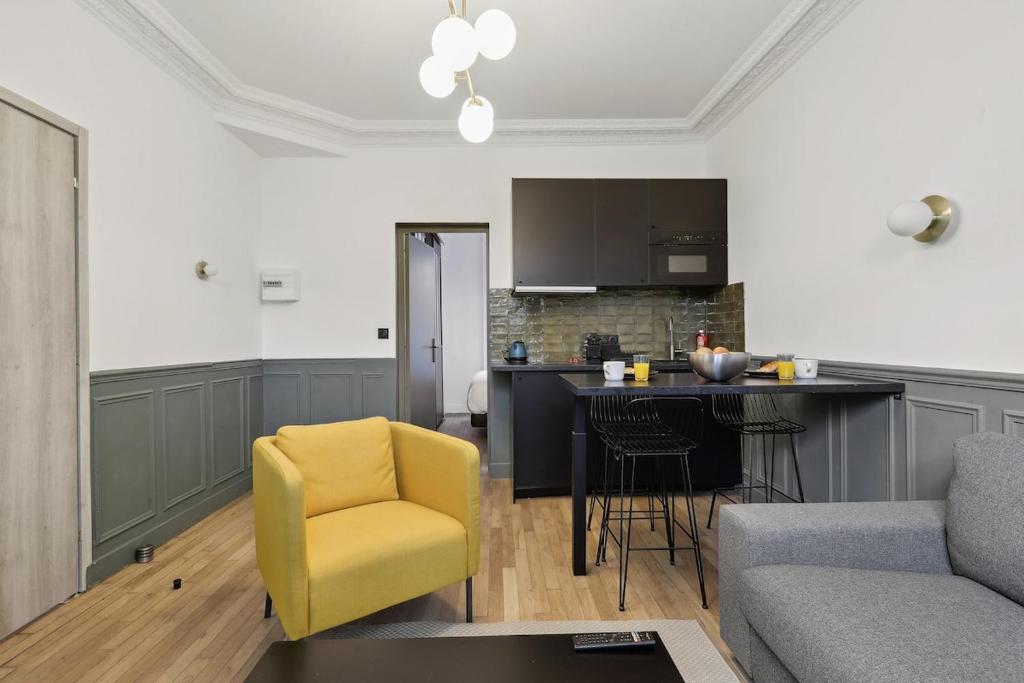een woonkamer met een gele stoel en een keuken bij Maisons Alfort 1 Modern flat in Maisons-Alfort