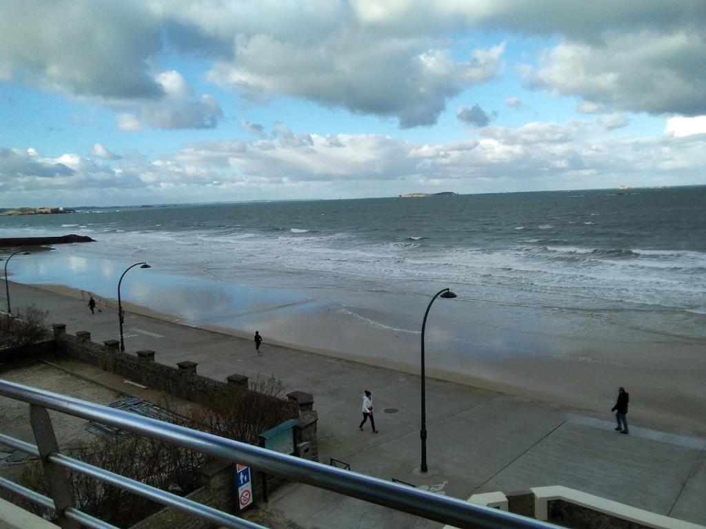 a group of people walking on the beach at Exceptionnelle vue front de mer avec accès direct plage in Saint Malo