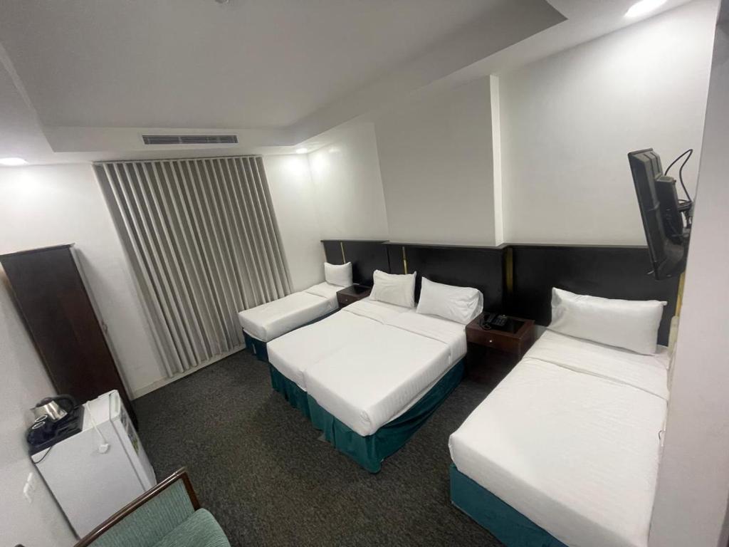 a hotel room with two beds and a television at فندق أمل المشاعر in An Nikāshah