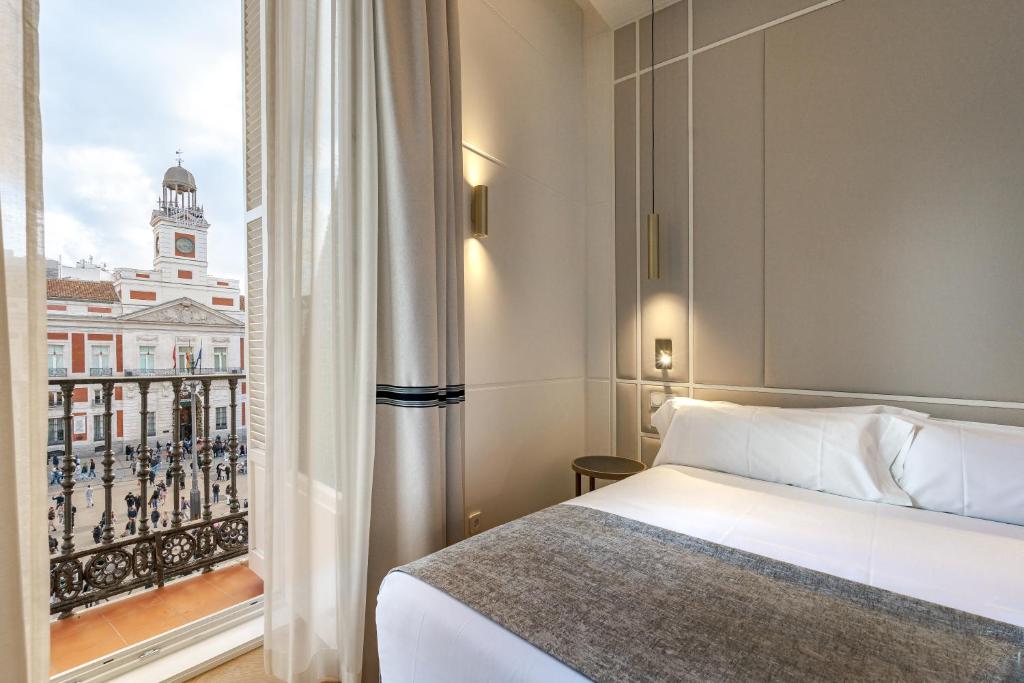 Schlafzimmer mit einem Bett und Blick auf ein Gebäude in der Unterkunft La Fonda de los Principes in Madrid