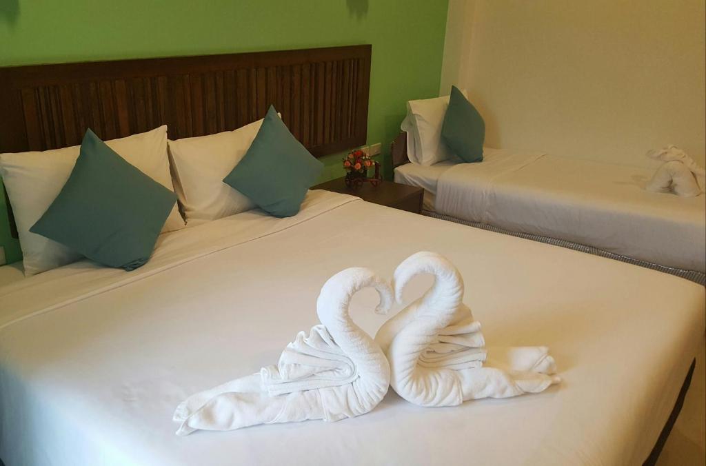 two swans making a heart shape on a bed at BS Airport at Phuket in Nai Yang Beach