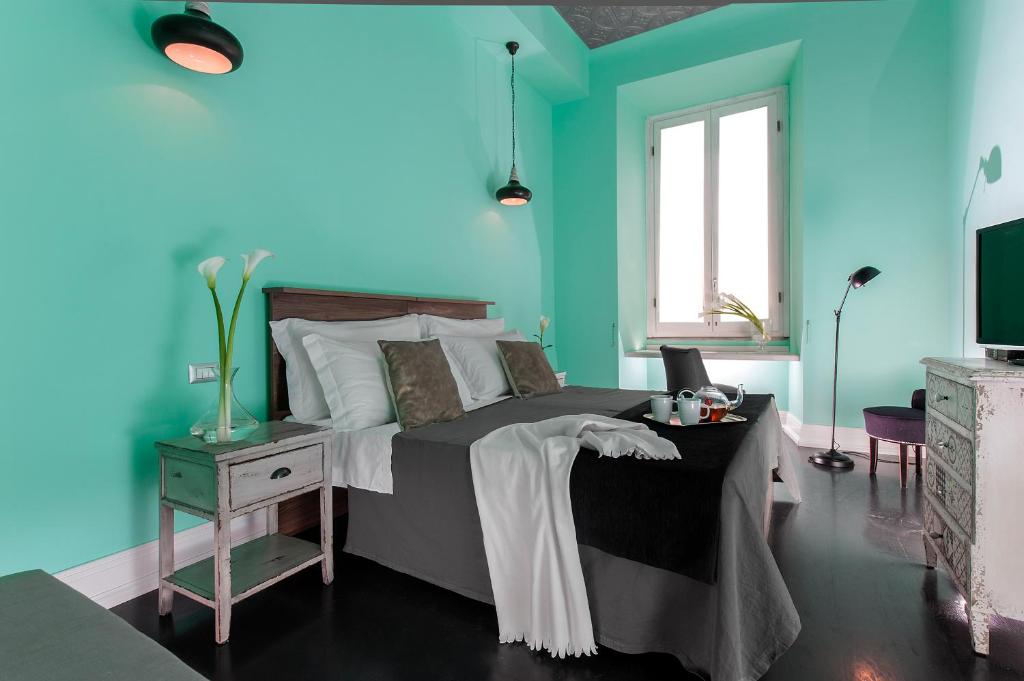 ローマにあるDaniele Manin Guesthouseの青いベッドルーム(ベッド1台、テレビ付)