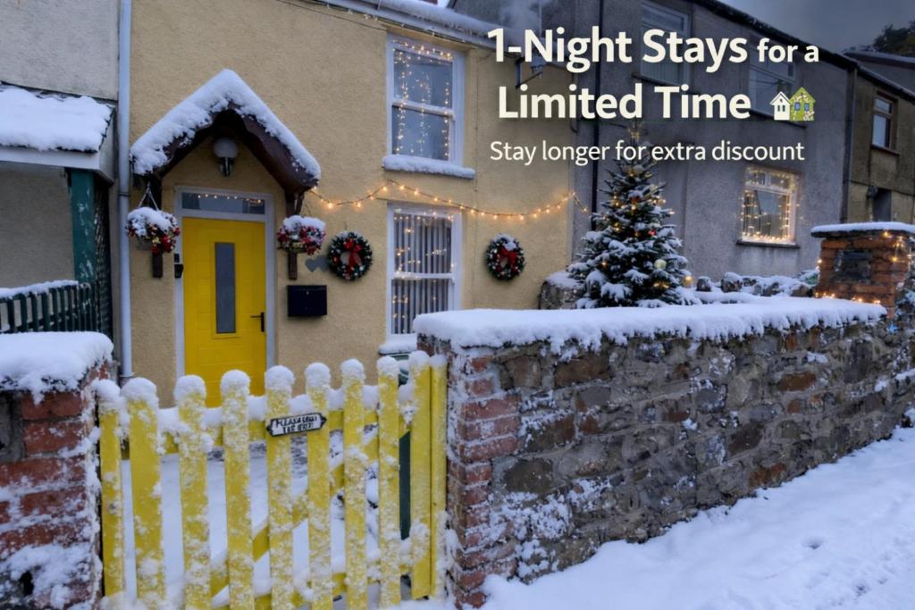 une maison avec une clôture blanche dans la neige dans l'établissement The Cwtch, Log Fire, Sleeps 6, Nr Zip World, Brecon and Bike Park Wales, à Aberdare