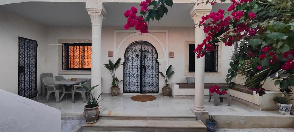 un salon avec une porte d'entrée ornée de fleurs roses dans l'établissement Villa Nour Kélibia, à Kelibia