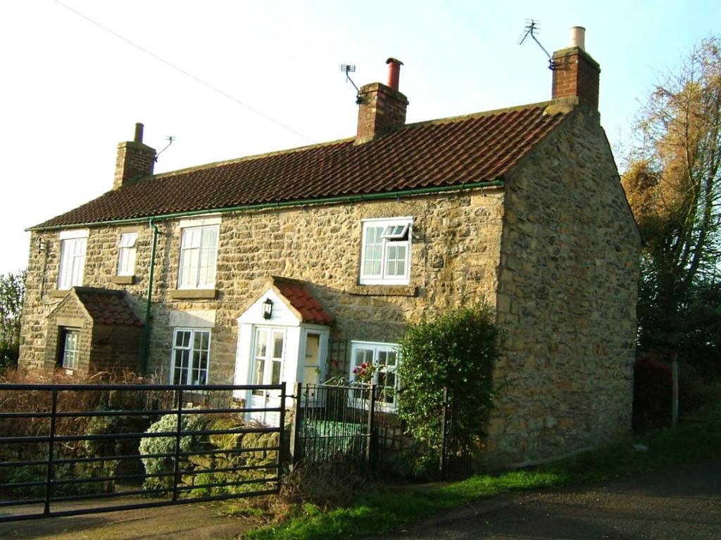 an old stone house with a gate in front of it at 1 Bed in Ampleforth oc-b34674 in Ampleforth