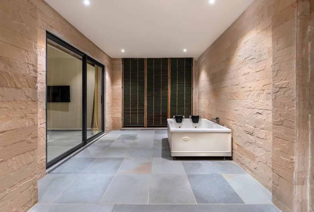 ein Badezimmer mit Badewanne und großem Fenster in der Unterkunft Nanda Hill Resorts, Udaipur in Chirwa