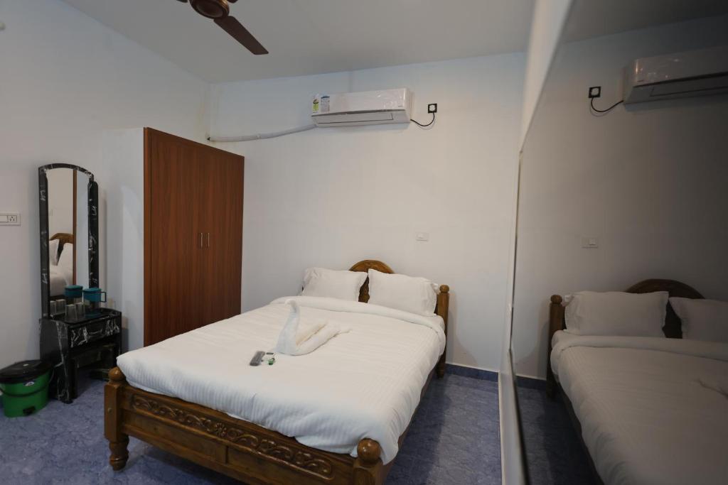 ein Schlafzimmer mit 2 Betten und einer Wandheizung in der Unterkunft AK Residency Auroville in Kuilapayam