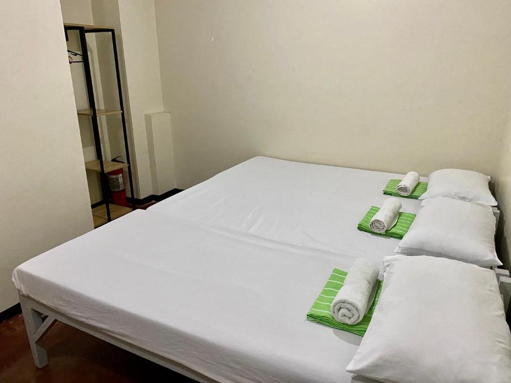 un letto bianco con asciugamani in una stanza di Mybed Dormitory a Cebu City
