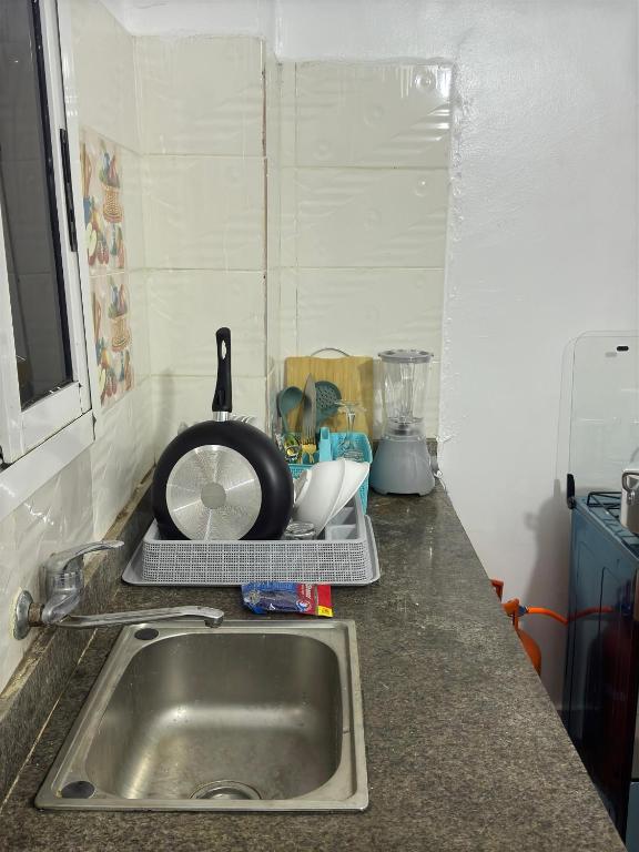 アビジャンにあるAKAWABA Residenceのキッチンカウンター(シンク、キッチン用品付)