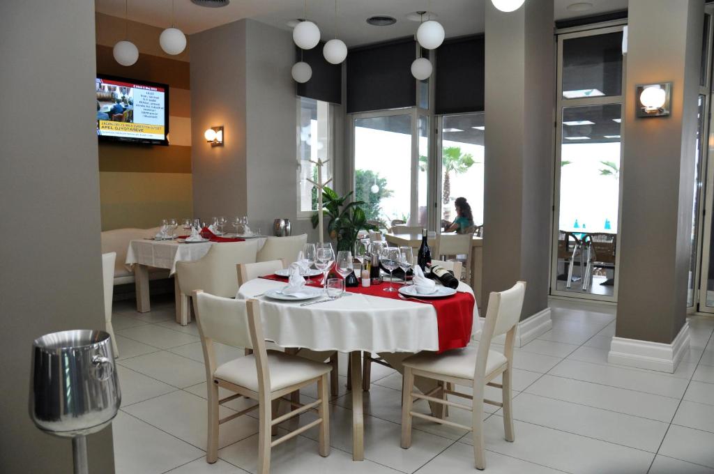 a dining room with a white table and chairs at Hotel Vila Lule in Durrës
