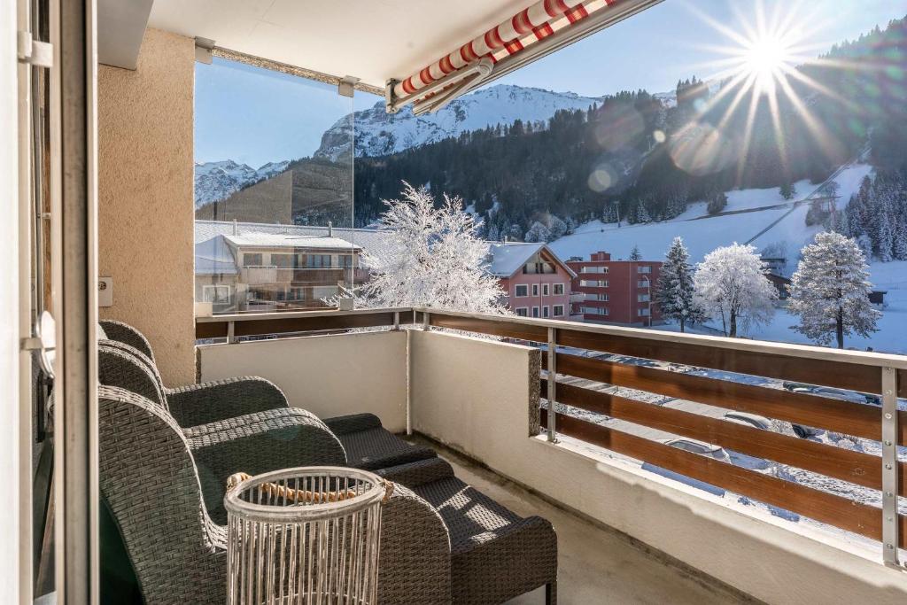 een balkon met stoelen en uitzicht op een besneeuwde berg bij Titlis Studio Engelberg with Balcony great View in Engelberg
