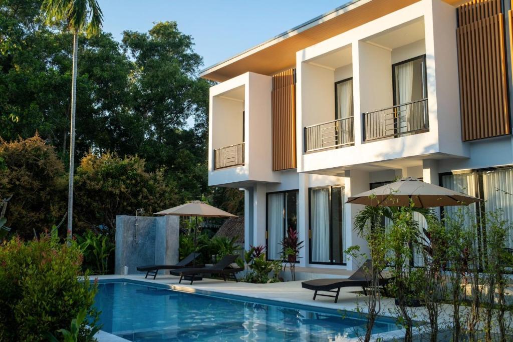 een villa met zwembad voor een gebouw bij Sinapa Suites in Ko Pha Ngan