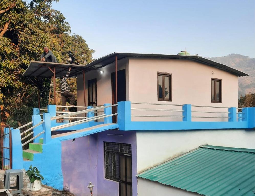 een man op het balkon van een huis bij Nature valley home stay in Marchula