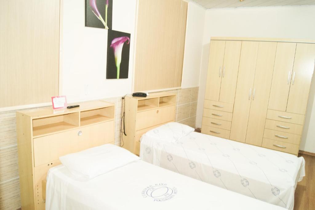 瓜鲁柳斯Cumbipar King Hotel的带两张床和镜子的客房