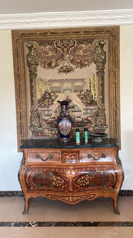 a wooden dresser with a vase on top of it at فيلا كامله للايجار in Kafr Ghaţāţī