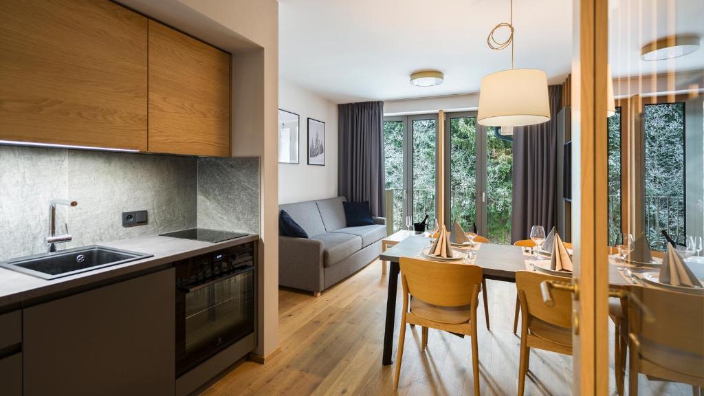 a kitchen and living room with a table and chairs at BARTAL APARTMENTS - Špindlerův Mlýn in Špindlerův Mlýn