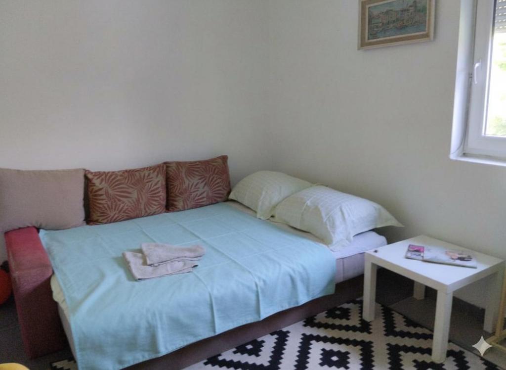 a small room with a bed and a table at Summer Garden View in Belgrade
