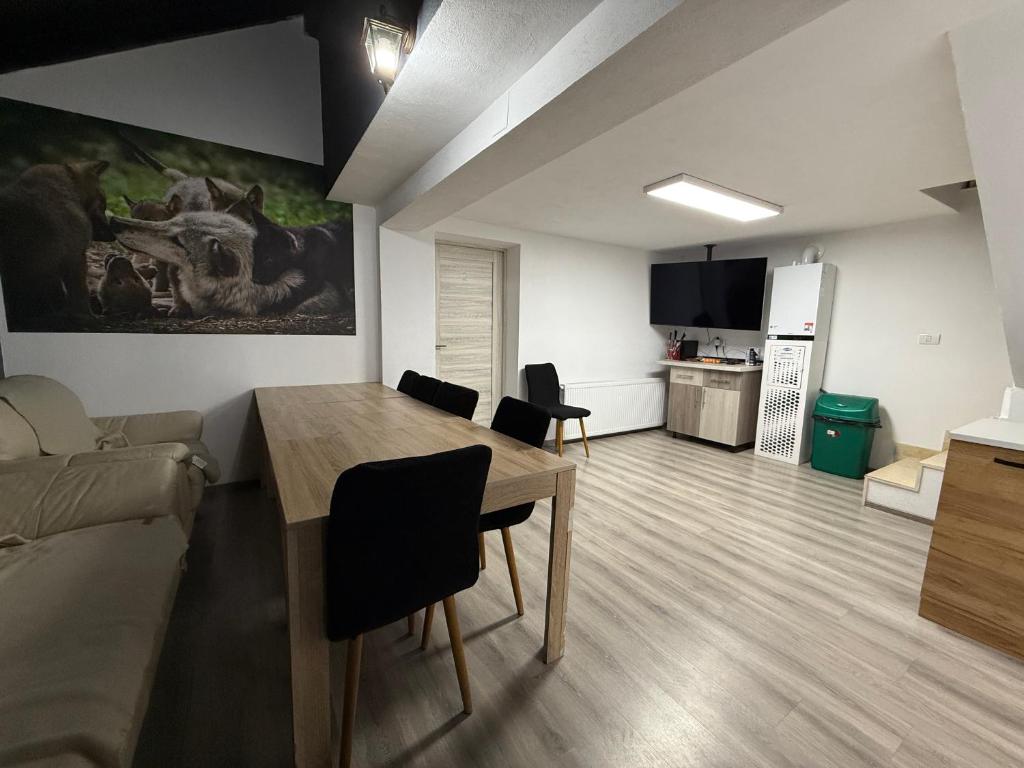 a living room with a table and a couch at Casa Lupilor 2 Vidraru in Căpăţîneni-Ungureni