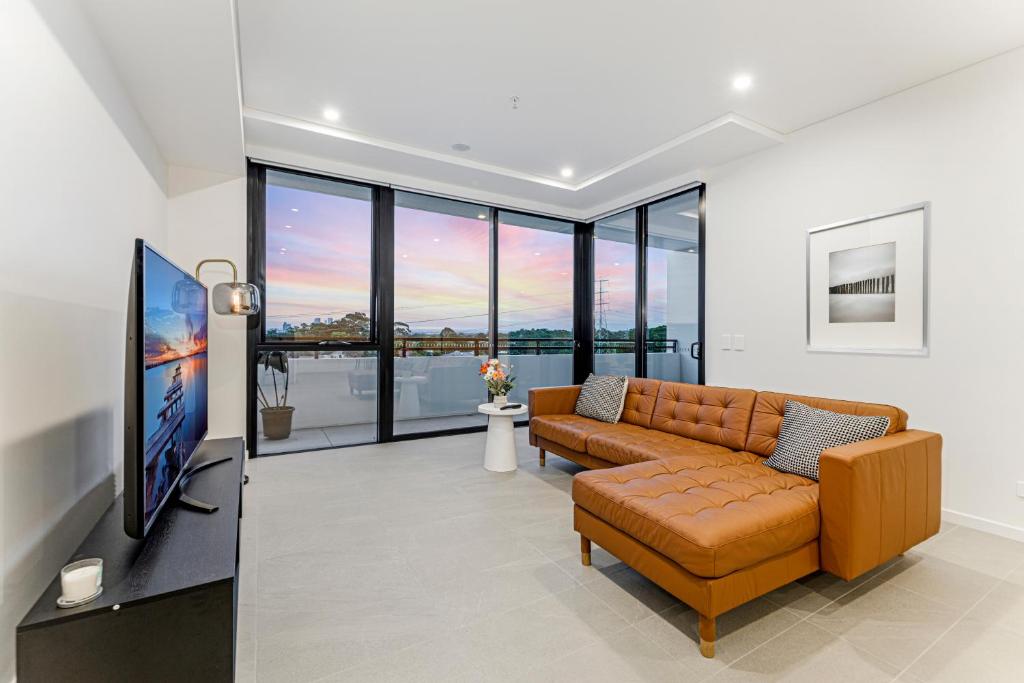 a living room with a couch and a tv at Modern 2BR Free parking near Olympic park in Sydney