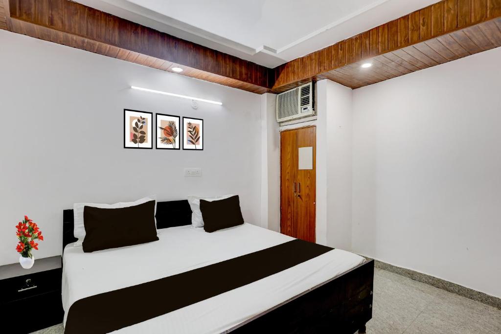 a bedroom with a white bed and wooden walls at Collection O Sector 18 Noida Formerly True Residency in Okhla