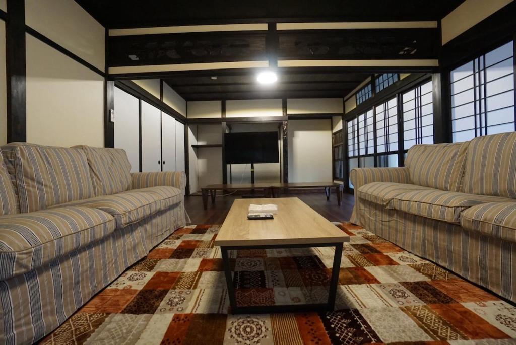 un soggiorno con due divani e una TV di Katata Biwa House a Otsu