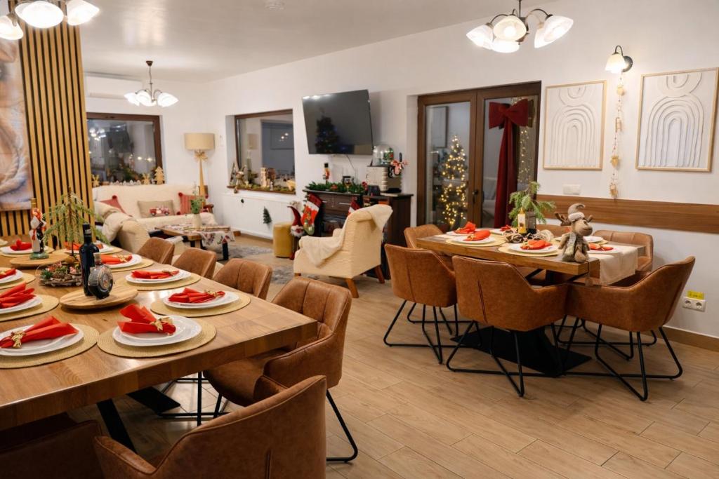 a living room with tables and chairs and a christmas tree at Cazare Colibița Casa Lipan cu jacuzzi, foișor și loc de joacă in Colibiţa